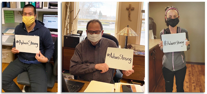 Auburn Homes & Services employees holding #AuburnStrong signs.