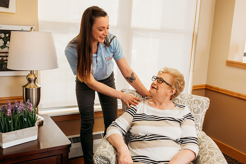 A care attendant at Auburn Courts in Chaska chats with a resident