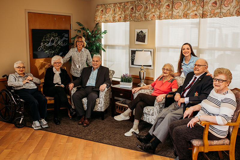 Two staff members and a group of assisted living residents at Auburn Courts in Chaska