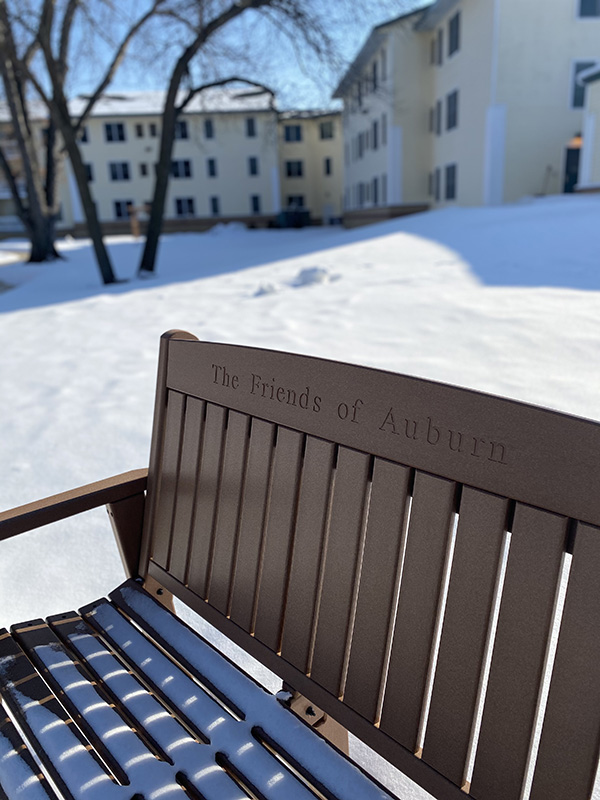 A Moravian foundation donor bench outside in the snow