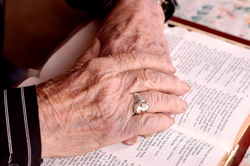 Auburn Manor resident's hands on a Bible