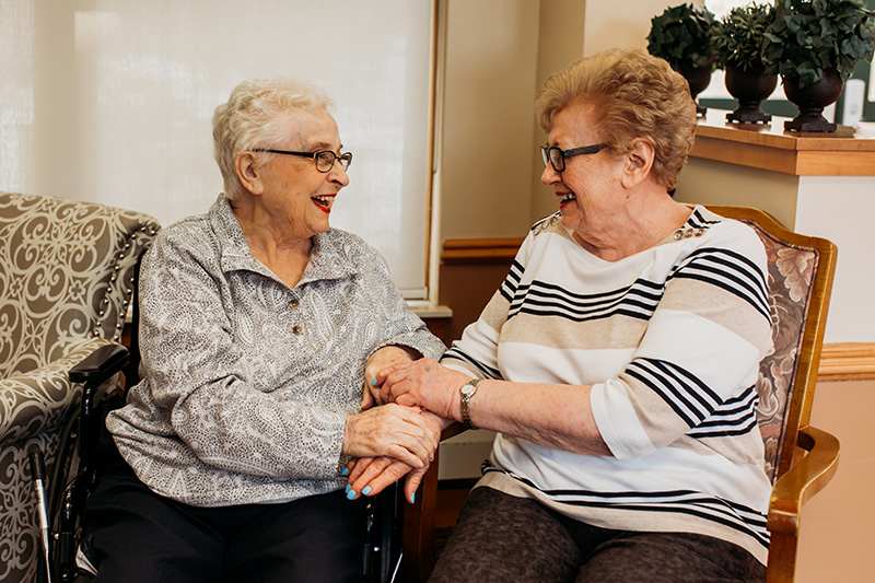 At Auburn Courts in Chaska, two seated women laugh