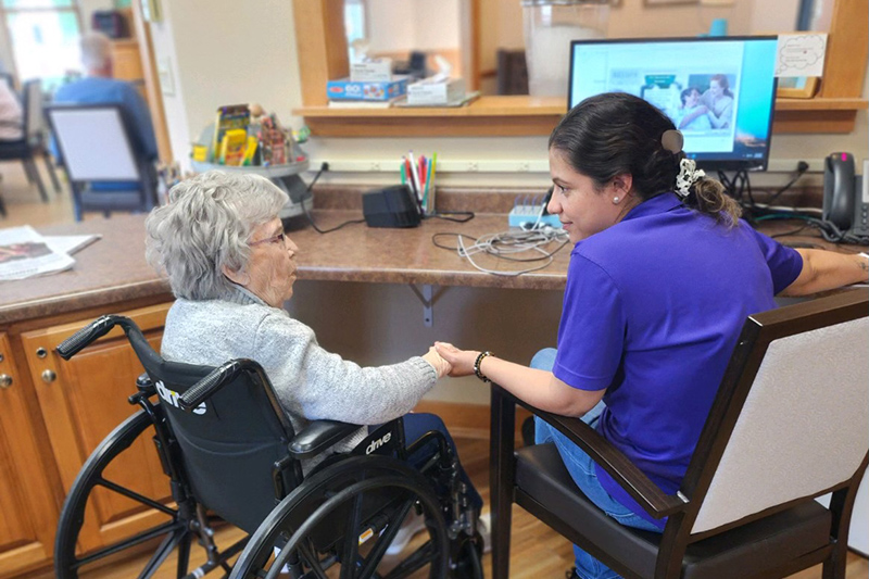 Resident and staff member holding hands at Auburn Courtyard